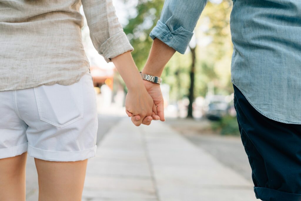 Man and woman holding hands while taking a walk