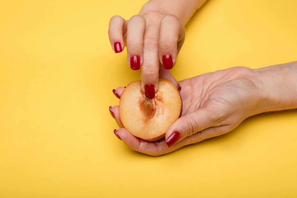 A woman touching a cut peach