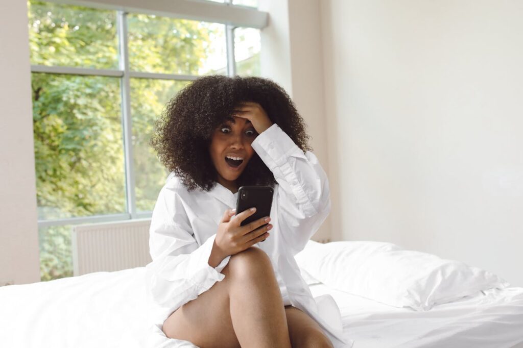 A surprised woman in a bedroom.