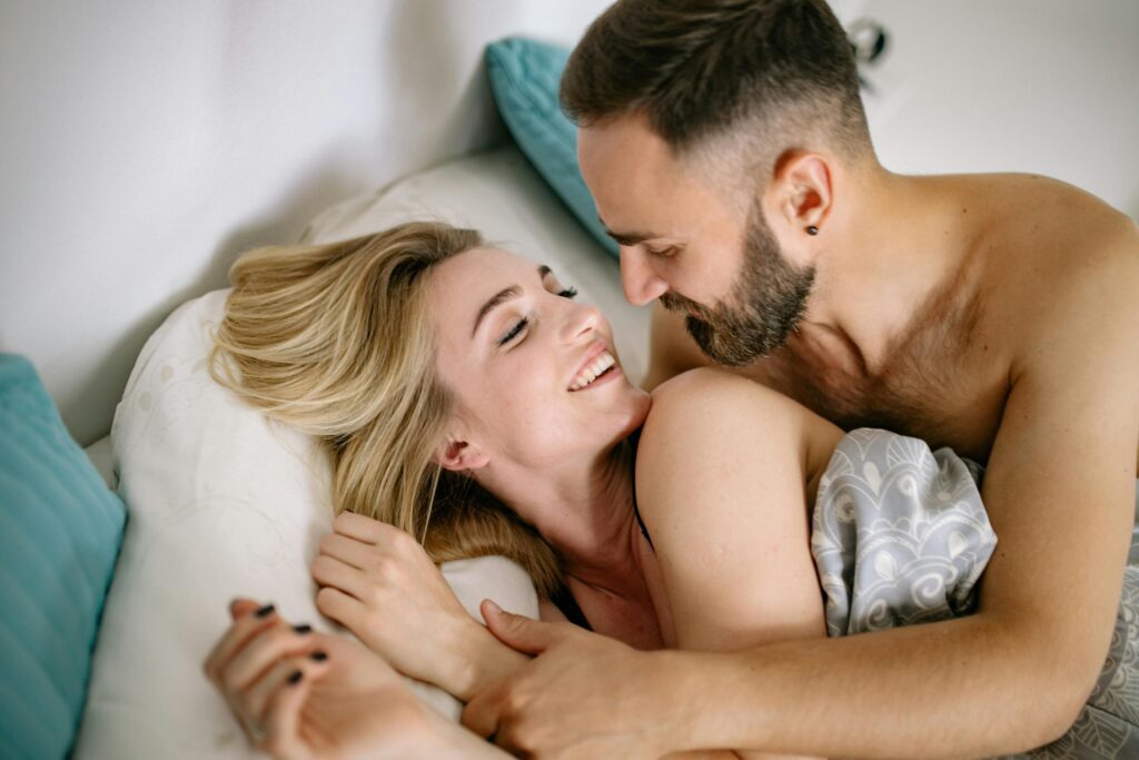 man and woman cuddling in bed