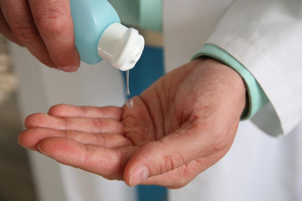 A doctor applying lubricant to their hands